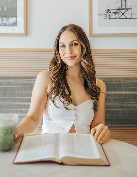 Alison sitting with an open Bible and matcha in a coffee shop